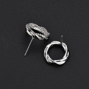 Macro shot of silver twisted earrings with micro-paved AAA cubic zirconia on black background