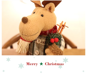 Close-up of reindeer plush toy with tartan vest, wooden ski poles and Merry Christmas sign
