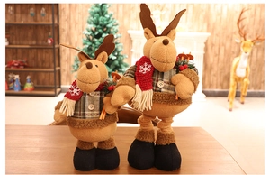 Detailed view of two Christmas reindeer plush dolls in red and plaid outfits