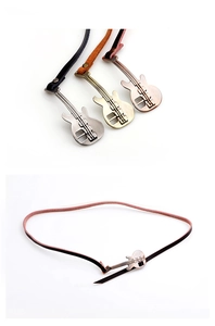 Detailweergave van gitaarvormige metalen gespen in zilver en brons op leren riemen voor