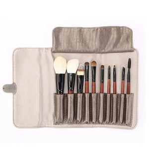 Professional 11-piece makeup brush set with wooden handles and a brown fabric roll-up bag