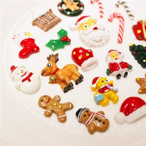 Assorted Christmas resin charms featuring Santa, reindeer and snowman on a white plate