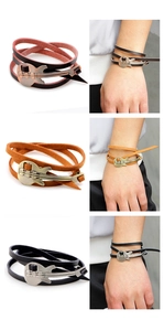 Detailweergave van lederen gitaararmbanden in zwart en bruin met metalen bedeltje