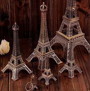 Vintage bronze Eiffel Tower metal models in six sizes displayed on a rustic wood surface