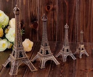 Detailed view of four vintage bronze Eiffel Tower statues in various sizes on wood