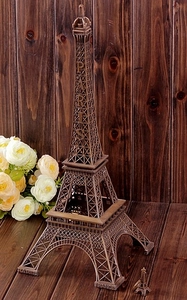 Detailed bronze Eiffel Tower metal model with matching keychain on dark wood background