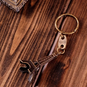 Detail of vintage bronze Eiffel Tower keychain on dark wood with France engraving