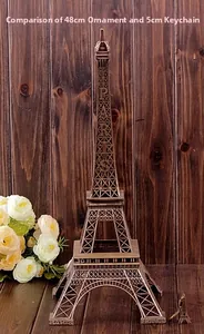 Eiffel Tower metal figurines in 48cm and 5cm sizes on a rustic wooden background