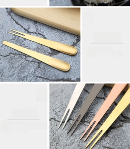 Detail view of multi-color stainless steel fruit forks with polished finish and dual tines