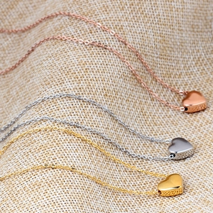 Detail view of heart pendants in rose gold, silver and gold finish on fine chains