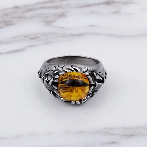 Retro vintage titanium steel ring with a magical yellow eyeball gemstone on marble background