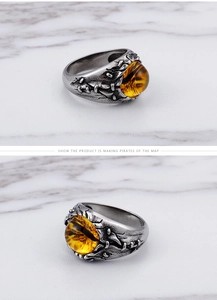 Macro detail of gothic tiger eye ring featuring a dragon eye and vintage stitch patterns
