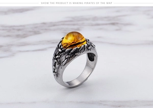 Macro detail of men's vintage gothic ring with amber gemstone on marble background