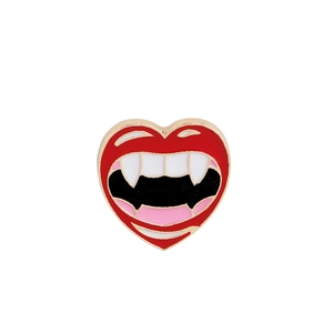 Detailed close-up of a heart-shaped vampire lips enamel pin with white fangs and gold edges