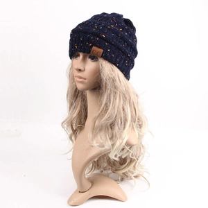 Detail of dark blue knit beanie with colorful speckles and C.C brown leather patch