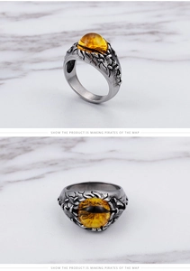 Detail of vintage punk titanium ring featuring yellow devil's eye stone and claw carving