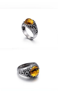 Macro detail of gothic men's ring featuring amber eye stone and vintage silver texture