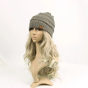 Close-up of knit winter beanie featuring dark grey marled yarn and brown leather C.C logo