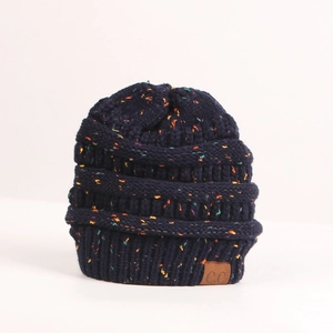 Detail of navy knit beanie with colorful confetti specks and brown leather C.C logo patch