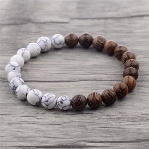 Beaded bracelet with white marble stone and dark brown wood beads on rustic surface