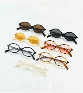 Flat lay of retro oval sunglasses in black, cream, and tortoiseshell frames with tinted lenses