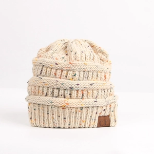 Close-up of cream knit beanie with colorful flecks and a brown leather logo patch