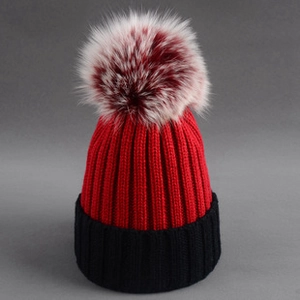 Close-up of the red and black knit pattern with a large fluffy faux fur pompom on top