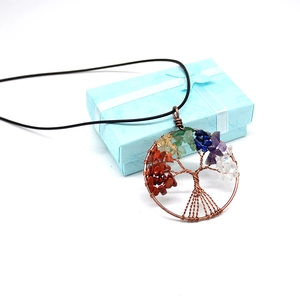 Macro shot of tree of life wire-wrapped pendant with colorful crystal chips and gift box