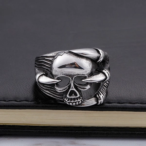 Vintage silver skull claw ring for men with punk gothic design on black leather surface
