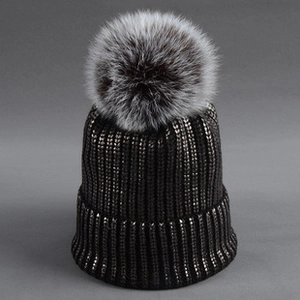 Detail of black knit beanie with sequins, metallic yarn and large grey faux fur pompom
