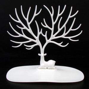 Close-up of white deer antler jewelry stand with stable base on black background