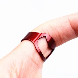 Macro shot of a red coated stainless steel ring bottle opener worn on a finger
