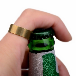 Close-up of a gold stainless steel bottle opener ring removing a beer bottle cap