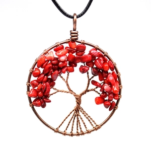 Detail of tree of life copper wire wrapped necklace with red stone pendant on white background