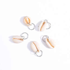Close-up of five off-white natural shell charms with silver metal rings for DIY hair styling