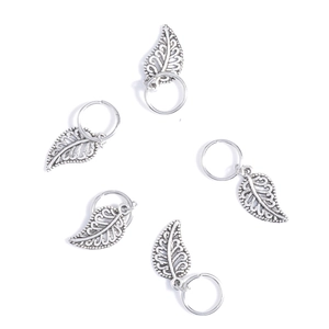 Detailed view of five silver leaf-shaped metal hair charms with rings for DIY braiding