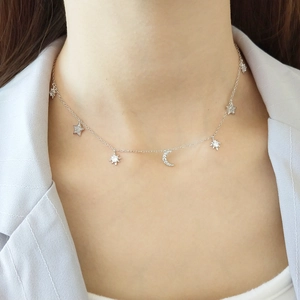 Close-up of a 925 sterling silver star and moon necklace on a model for jewelry detail
