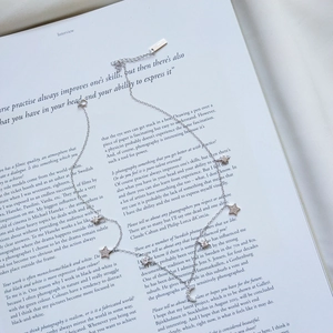 Detail of S925 sterling silver star and moon necklace on a lifestyle magazine background