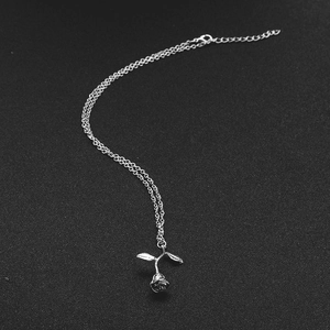 Detail of silver 3D rose flower pendant with leaf and lobster clasp on black background