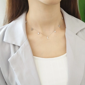 Close-up of a 925 sterling silver star and moon necklace on a professional model