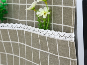 Close-up of khaki checkered linen microwave cover with delicate white lace border detail