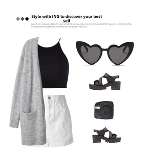 Flat lay of trendy heart shaped sunglasses with a grey knit cardigan and denim skirt outfit