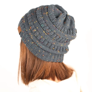 Detailed close-up of grey chunky knit slouchy beanie with colorful flecks and leather patch
