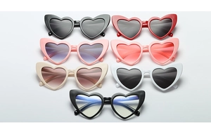 Flat lay collection of heart-shaped sunglasses in various colors with plastic frames