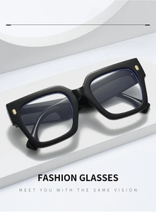 Detail of square black frame glasses with golden metal accents on the temple