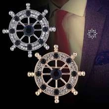 Detailed view of silver and gold nautical helm brooches with rhinestones on a purple suit