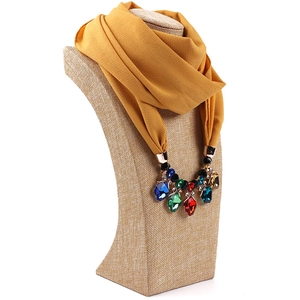 Detail of yellow chiffon scarf necklace with large multi-colored crystal pendants