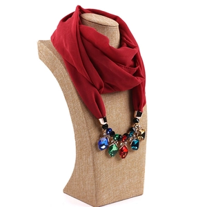 Detail of burgundy chiffon scarf featuring gold alloy necklace with multicolor gemstones