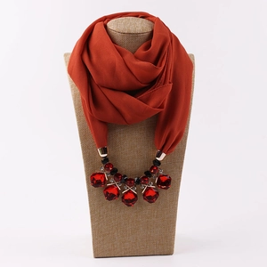 Detail of red resin gemstone and black beads on chiffon scarf necklace pendant