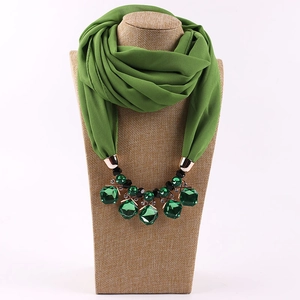 Detail of green chiffon scarf with emerald green geometric crystal necklace accessory